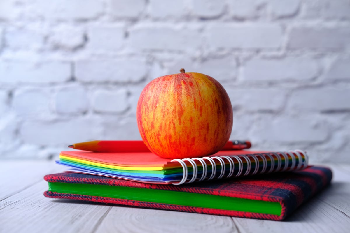 Close up of Apple on Stack of Notebooks on Table